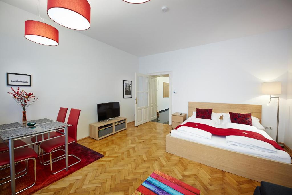维也纳施塔特哈勒 - 家庭城市公寓的一间卧室配有一张床、一张桌子和一台电视