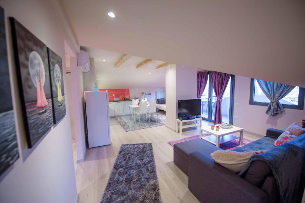 约阿尼纳New Loft Polixeni的一间带蓝色沙发的客厅和一间厨房