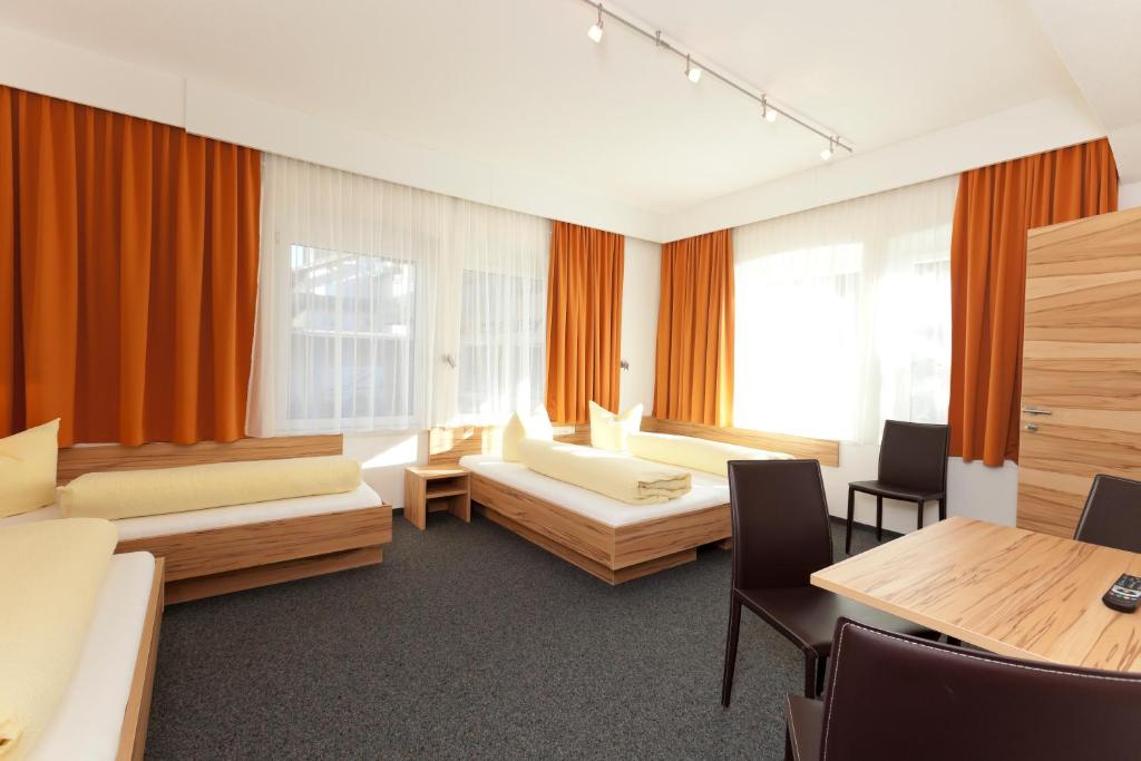 奥茨塔尔Hotel Garni Gletschertor的一间设有两张床和一张桌子及椅子的房间