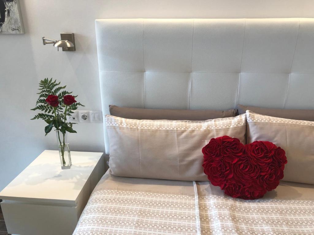 拉克鲁斯明珠公寓的床上的红色心枕,花瓶