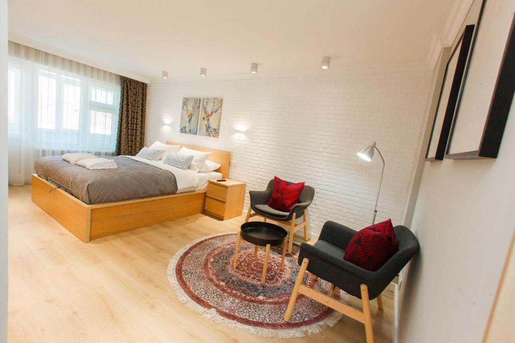 阿特劳Avangard Aparts - Avangard的一间卧室配有一张床和两把椅子