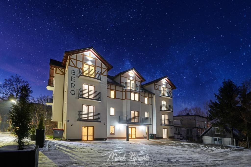 卡尔帕奇Apartamenty Berg Karpacz的一座晚上下雪的建筑