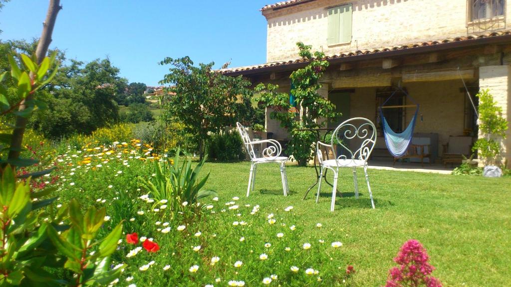 TavoletoPoggio Dei Prugnoli的两把椅子坐在房子的院子