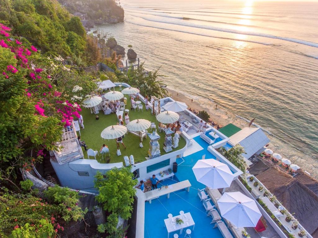乌鲁瓦图莫拉比托艺术克里夫别墅的享有带遮阳伞和海滩的游泳池的顶部景致