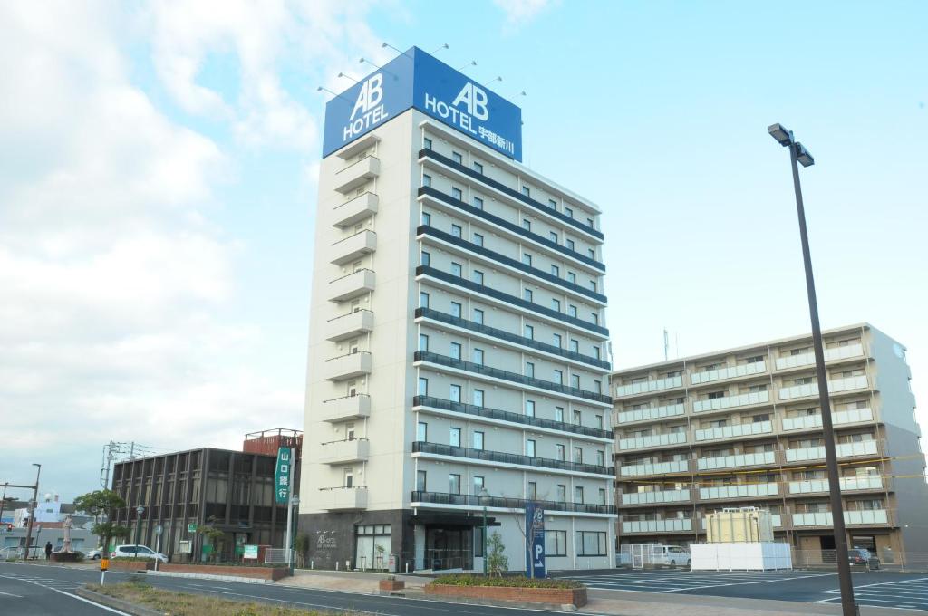 宇部AB Hotel Ubeshinkawa的蓝色顶部的高大的白色建筑