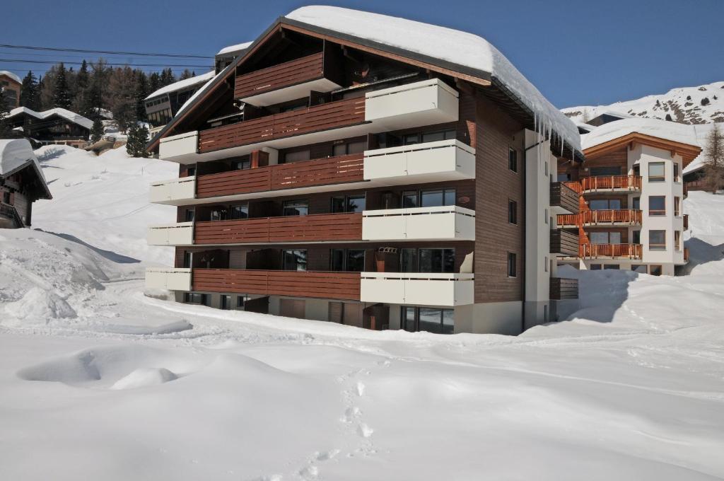 贝特默阿尔卑阿尔盆豪斯贝特默拉尔普酒店的雪中积雪的建筑物