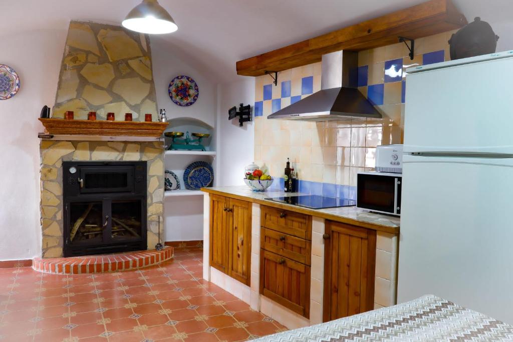 瓜迪克斯Cueva la kililla的一间带炉灶和壁炉的厨房