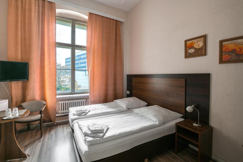 柏林潘森克拉斯科酒店的一间卧室配有一张床、一张书桌和一个窗户。