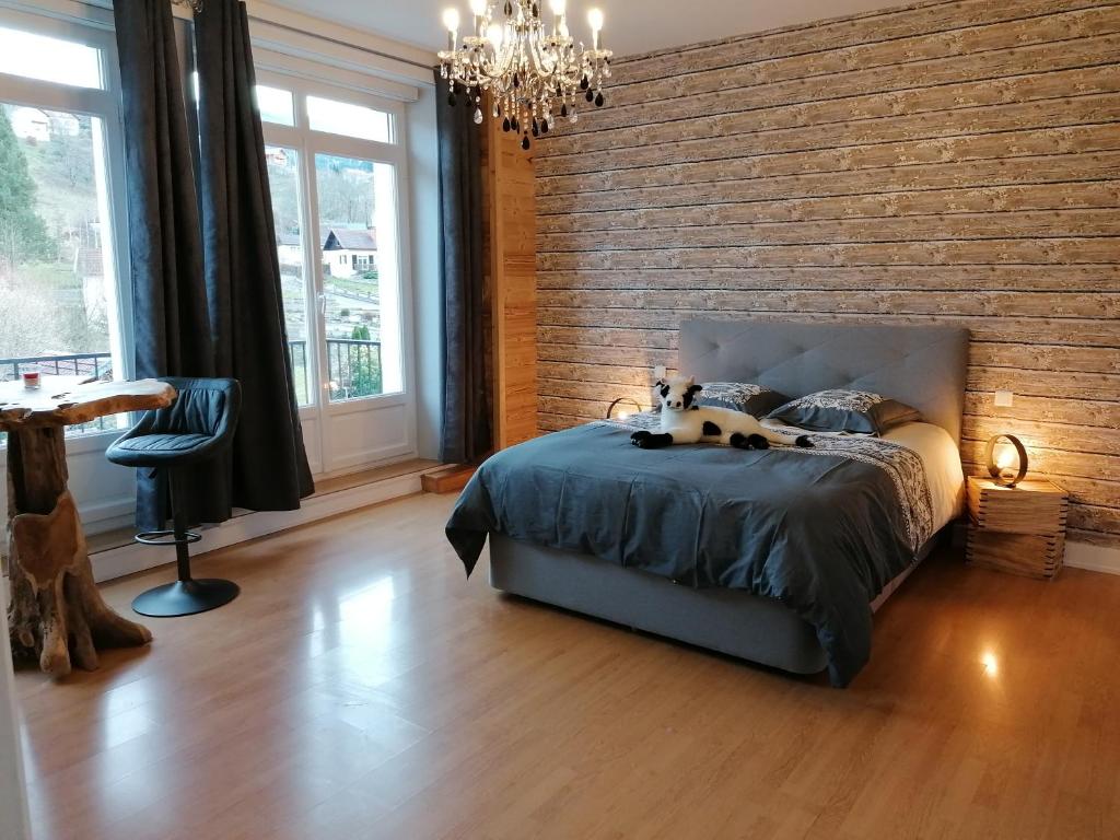 摩泽尔河畔圣莫里斯Chez MARLYSE-chambres et Table d'hôtes的一间卧室设有一张床和砖墙