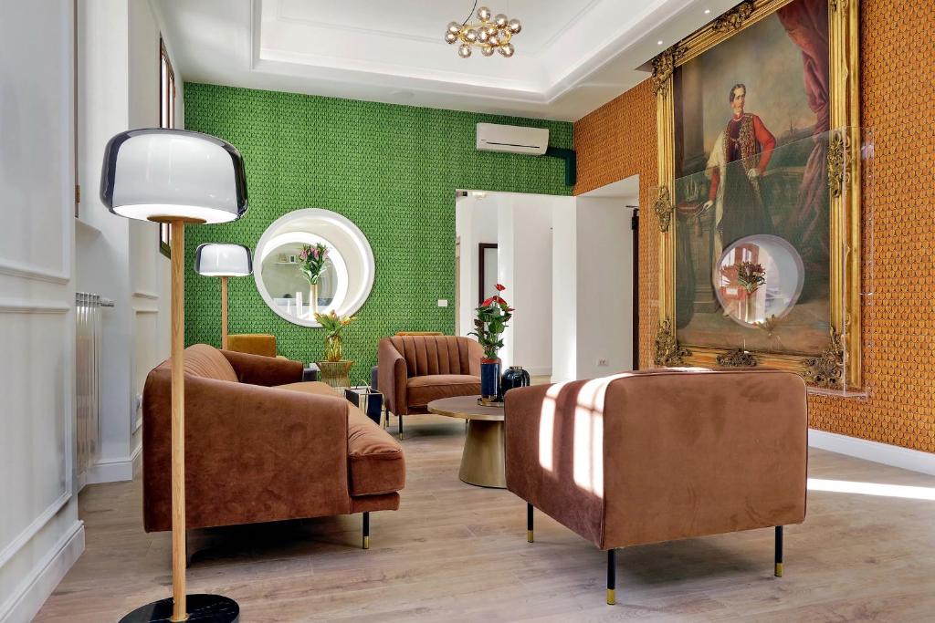 罗马Casa Santa Sofia的客厅设有绿色墙壁和棕色椅子