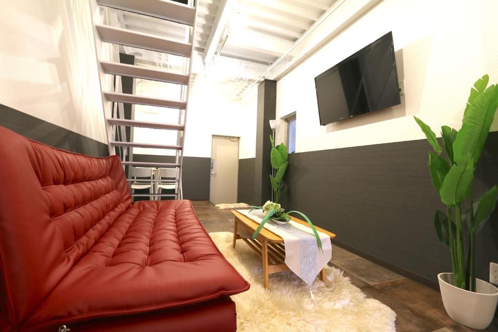 大阪EK1 Elizabeth Garden Kuromon的客厅配有红色沙发和平面电视