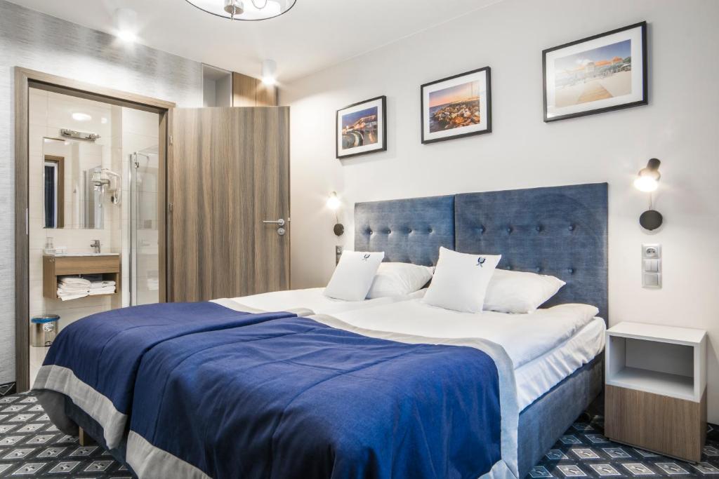 格但斯克Hotel Urbi的一间卧室配有一张大床和蓝色床头板