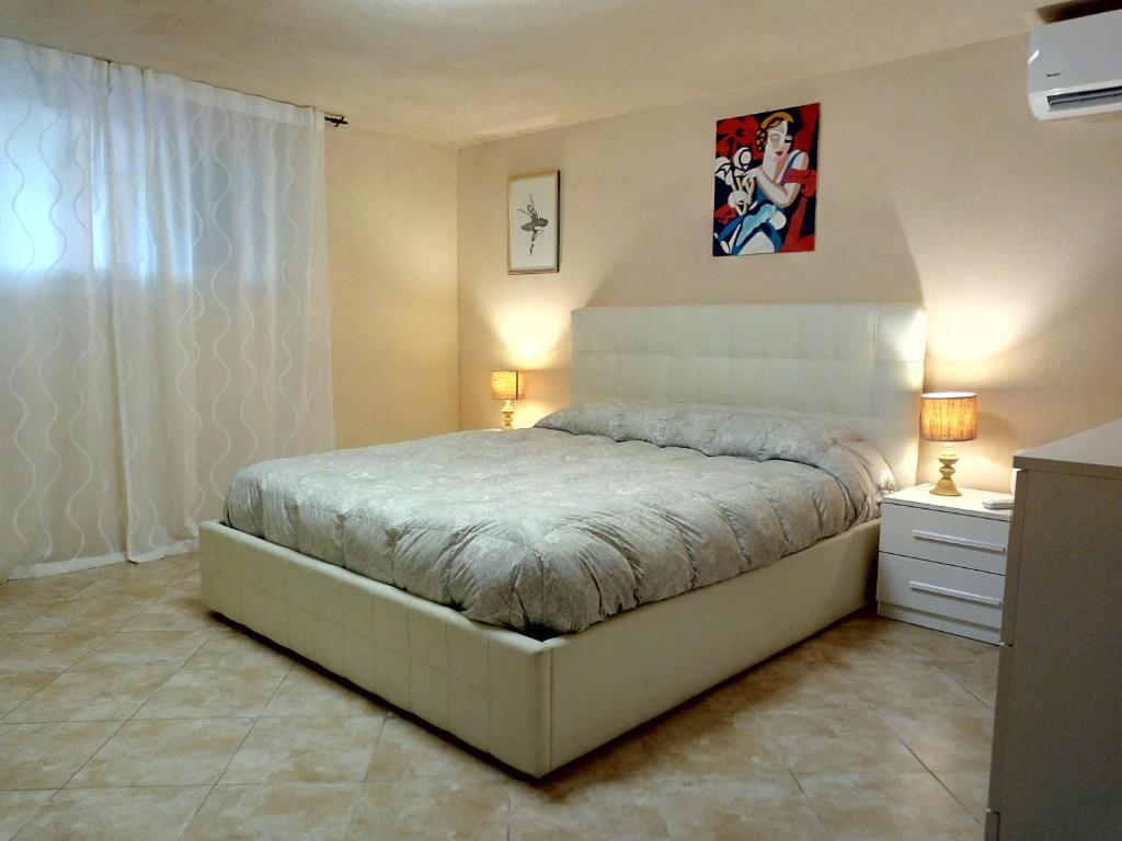 奎瑟塔Il Giardino di Patrizia的一间卧室配有一张床、两盏灯和一个梳妆台