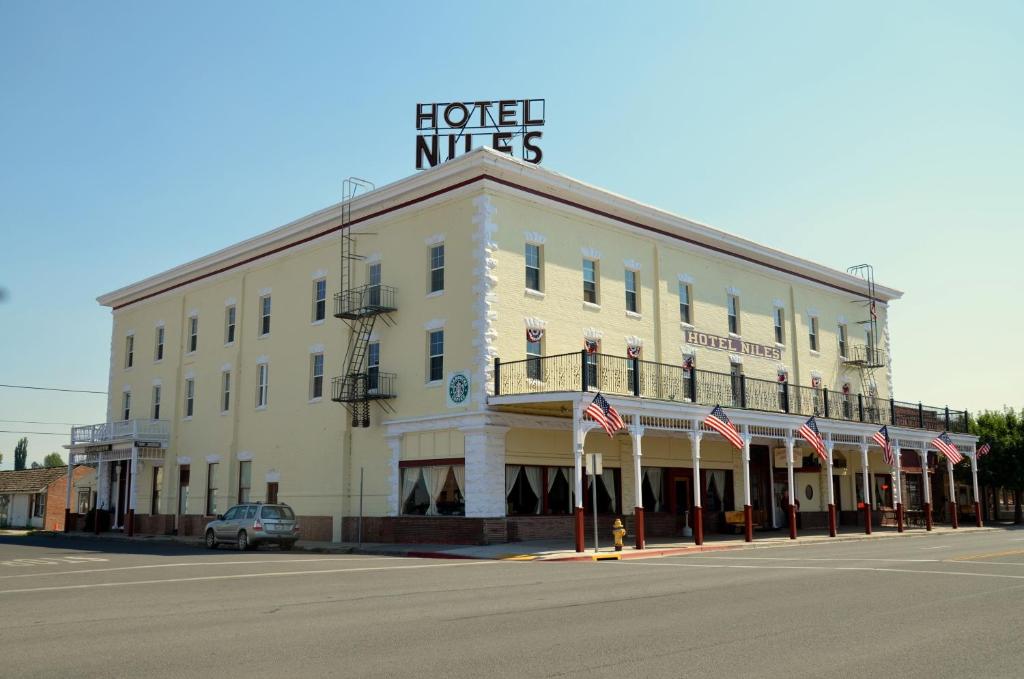 阿尔图拉斯Hotel Niles的一座白色的大建筑,上面有标志