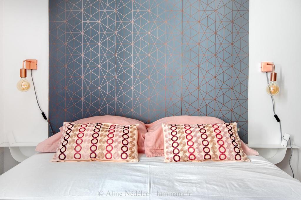 拉罗谢尔The Clock House, 3 étoiles的一张带粉红色枕头和蓝色墙壁的床
