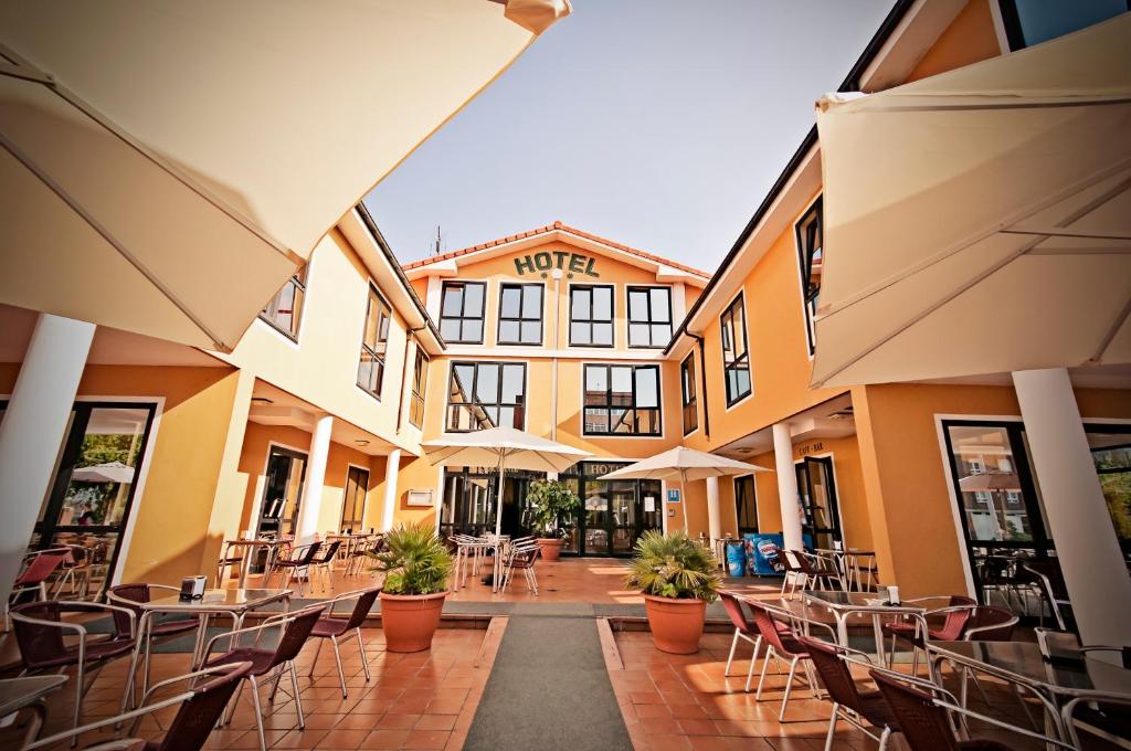 彼德拉斯布兰卡斯彼德拉斯内格酒店的一座带桌椅和遮阳伞的空庭院