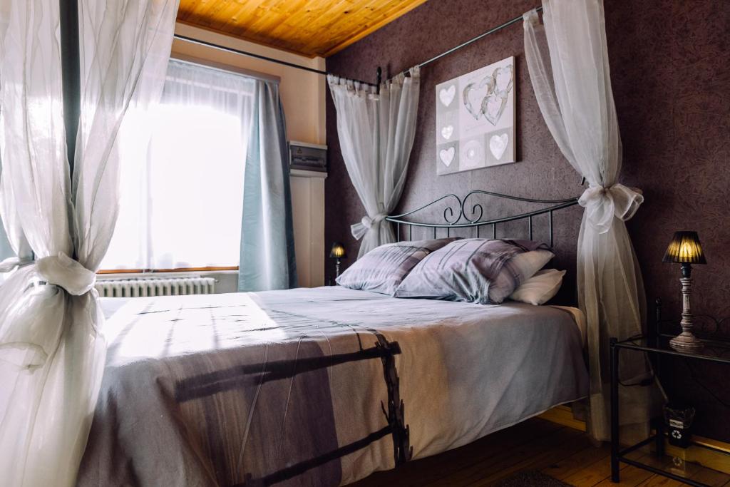 克诺克－海斯特't Eenvoud - Logies的一间卧室配有带窗帘的床和窗户