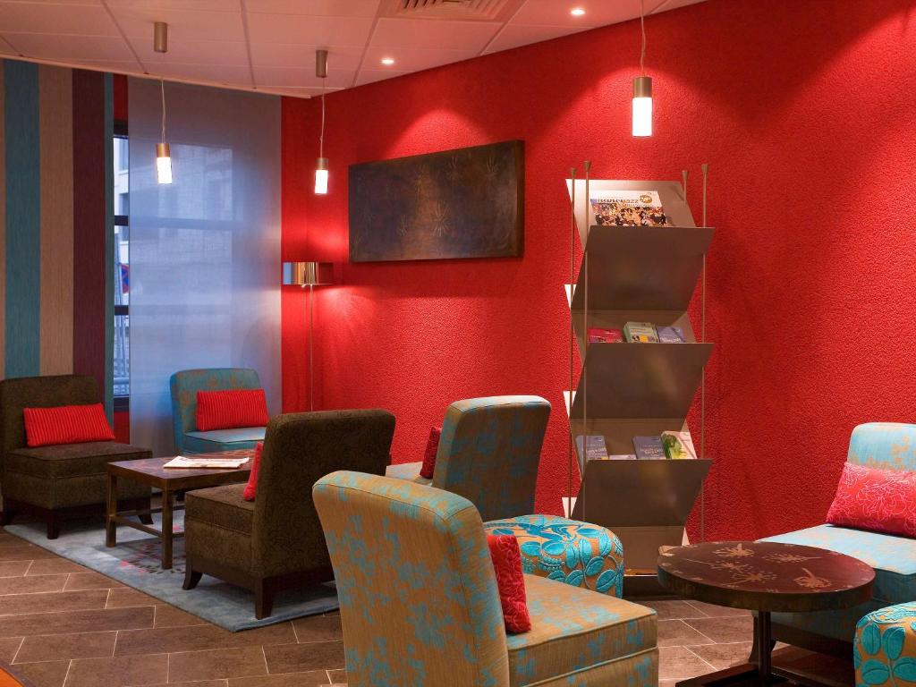 南希南希中心诺富特套房酒店的一间设有椅子和红色墙壁的等候室