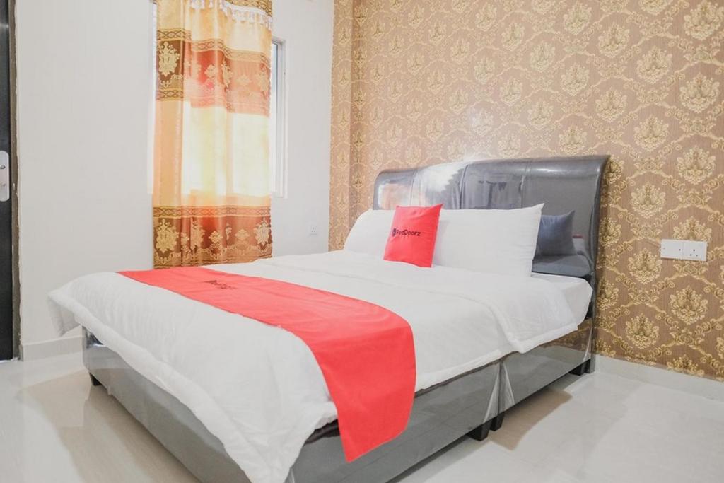巴淡岛中心RedDoorz Apartment @ Batam Centre 3的一间卧室配有一张床铺,床上铺有红色毯子
