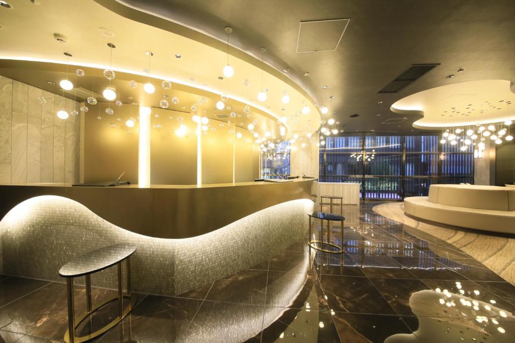 东京Quintessa Hotel Tokyo Ginza的大堂设有椅子,酒吧设有灯光