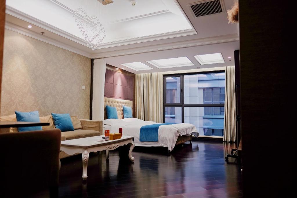 北京北京瑞英阁服务式公寓酒仙桥望京798艺术区店的一间卧室配有一张床、一张沙发和一个窗口