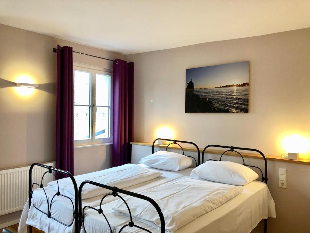 威斯巴登亚历山大酒店的一间卧室设有两张床和窗户。