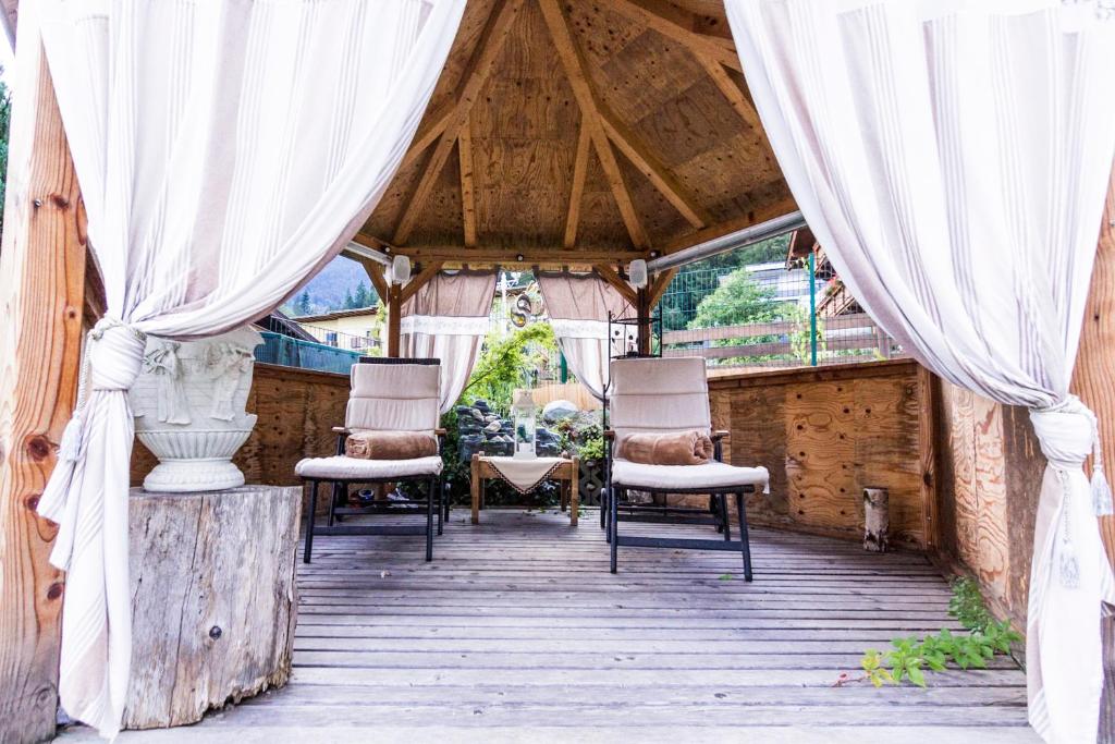 维辛加尔尼瓦尔德兰德旅馆的木甲板上的带椅子和窗帘的帐篷