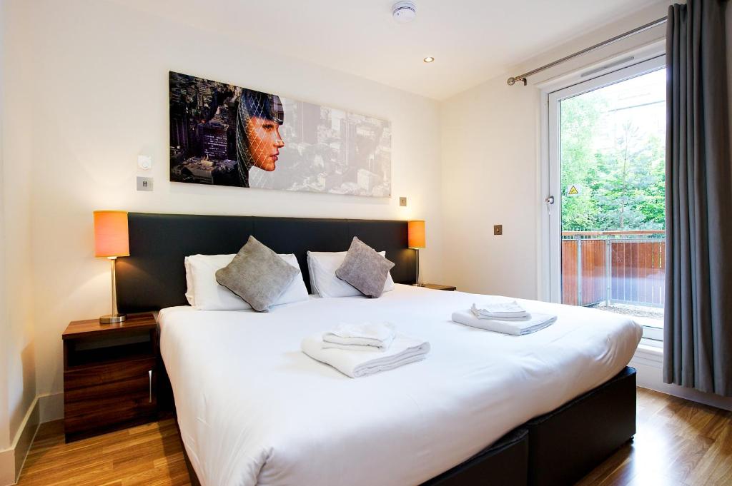 爱丁堡Staycity Aparthotels Edinburgh West End的卧室设有一张大白色的床和大窗户