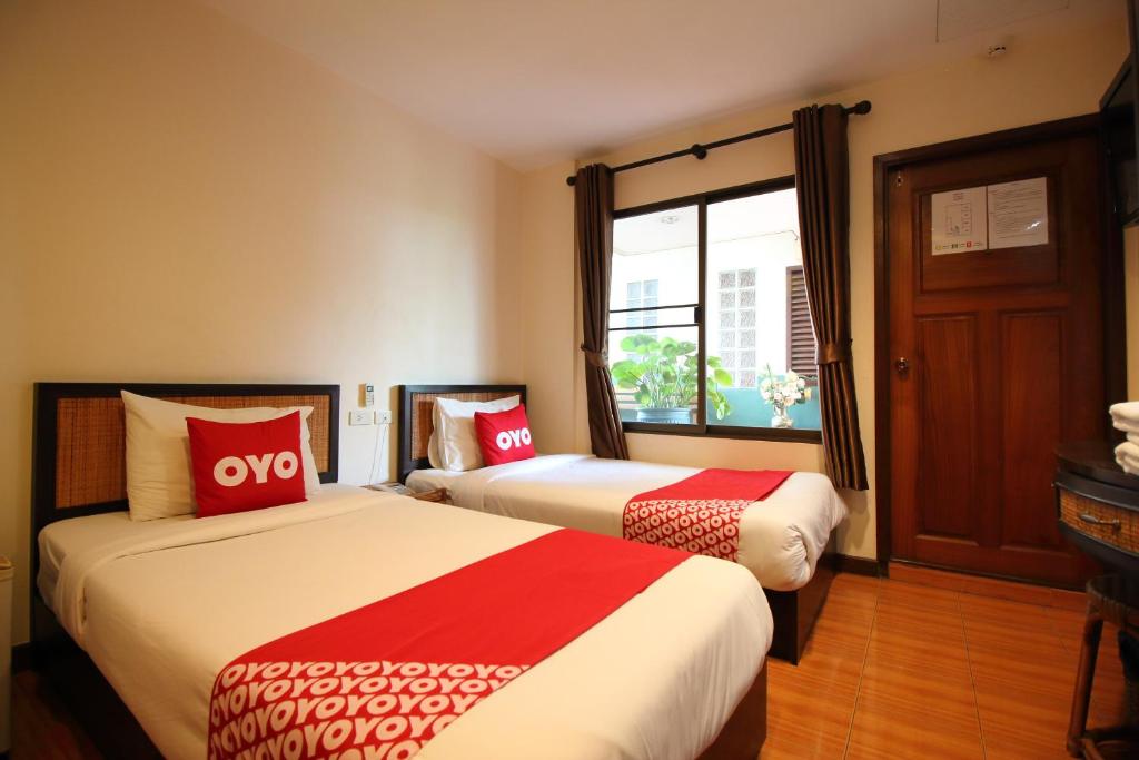 曼谷OYO 482 Pannee Lodge Khaosan - SHA Plus的酒店客房设有两张床和窗户。