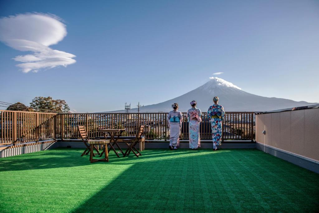富士河口湖HAOSTAY的三个人站在一个有山背景的阳台