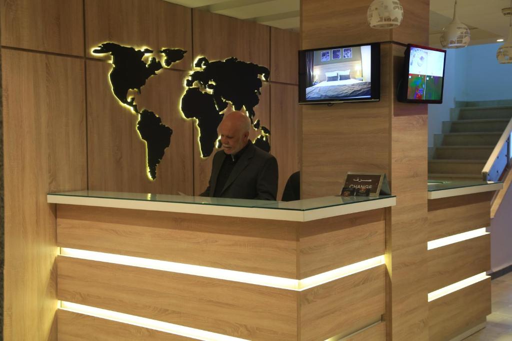 突尼斯MONDIAL HOTEL的坐在桌子上的人,墙上挂着一张世界地图