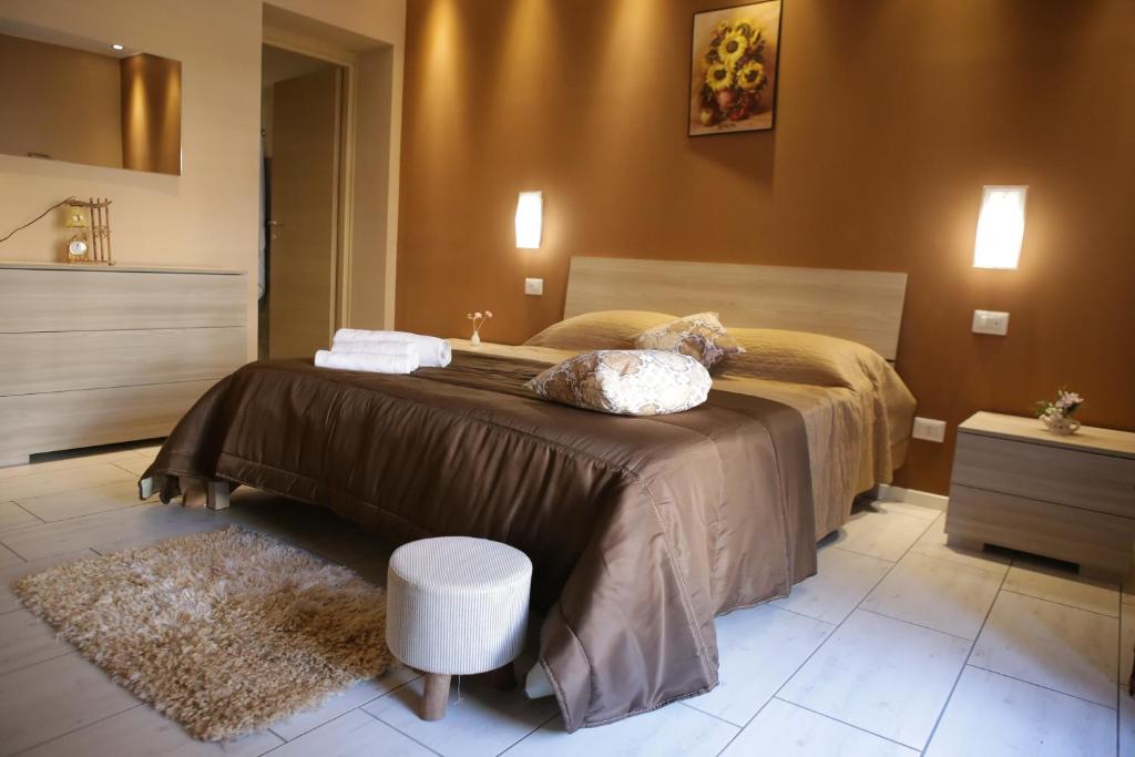 卡塔尼亚Primo Hotel的一间卧室配有一张大床和一张凳子