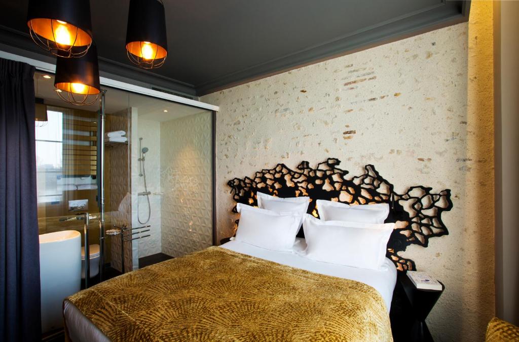 奥尔良印记Spa酒店的一间卧室配有一张大床和木制床头板
