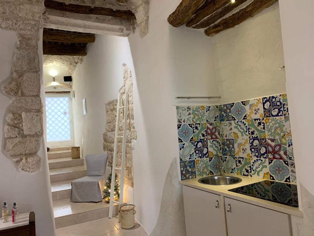 奥斯图尼Dimora Le Zagare的浴室设有水槽和马赛克瓷砖墙。