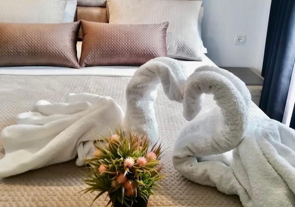 丹吉尔Appart Hotel Tanger Paname的床上方的两条毛巾天鹅