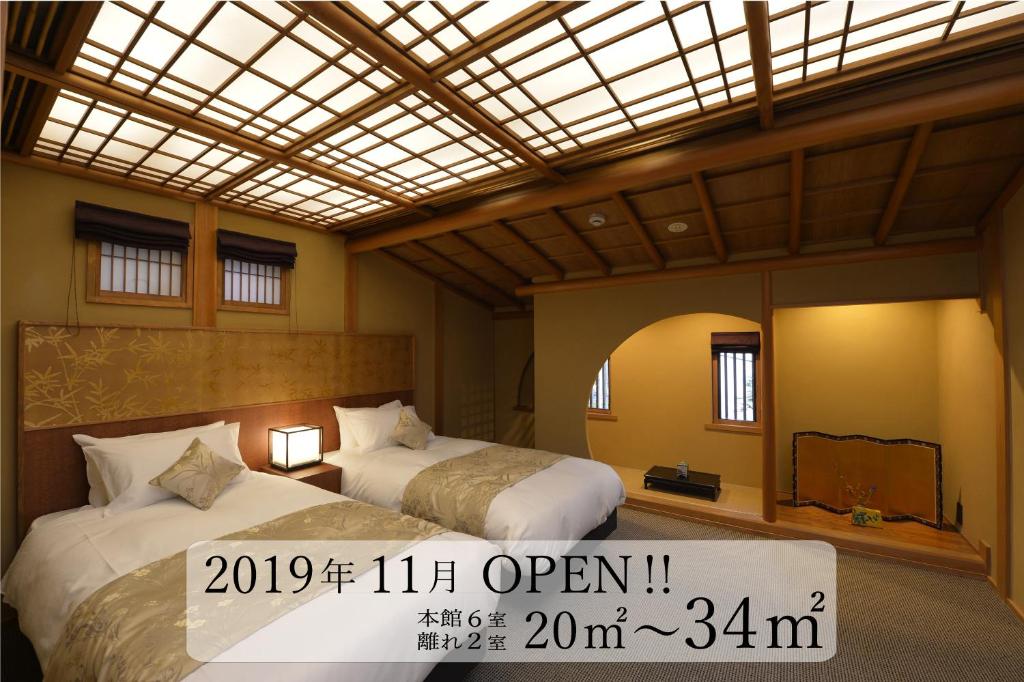 京都Gion Oyado Kikutani的酒店客房带两张床,上面标有价格标志