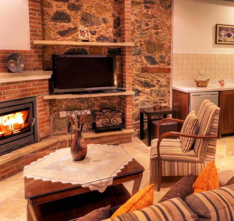 卡洛帕尼亚伊奥蒂斯阿彻蒂克伊米西尔洛酒店的客厅设有壁炉和电视。