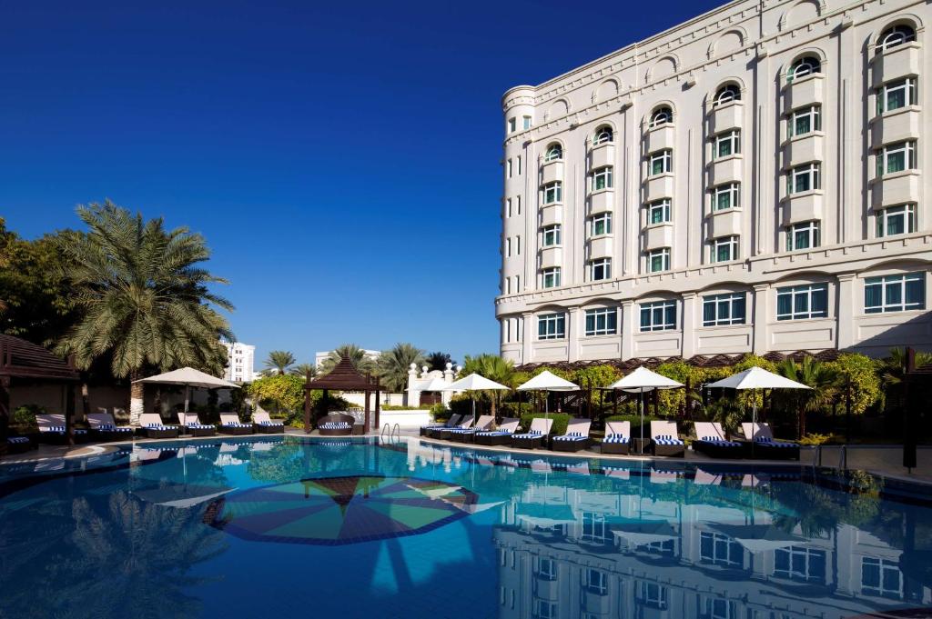 马斯喀特马斯喀特丽笙酒店的一座大型建筑,在一座建筑前设有一个游泳池