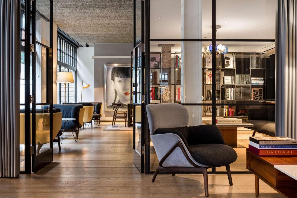 伦敦Radisson Blu Edwardian Mercer Street Hotel, London的客厅配有椅子和书架