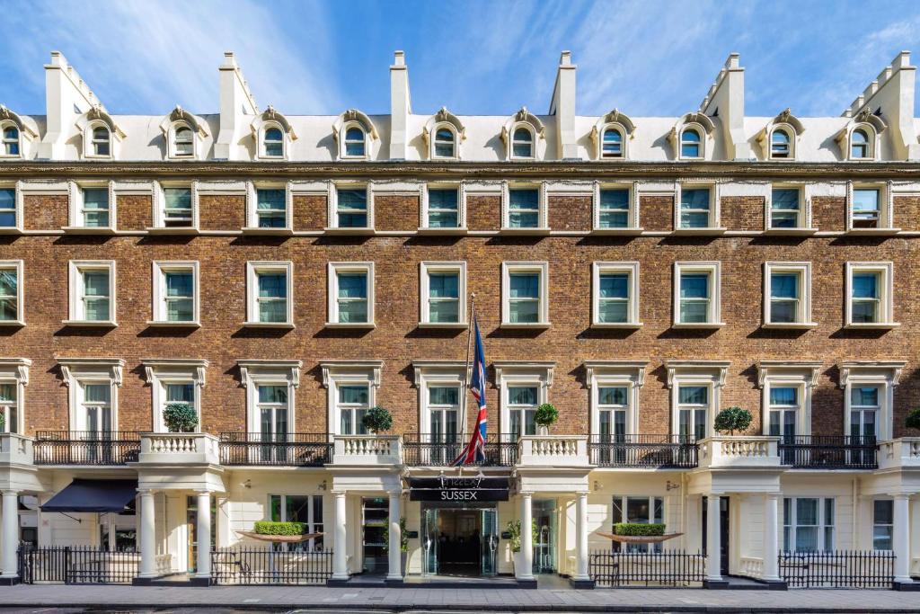 伦敦Radisson Blu Sussex Hotel, London的前面有旗帜的大砖砌建筑