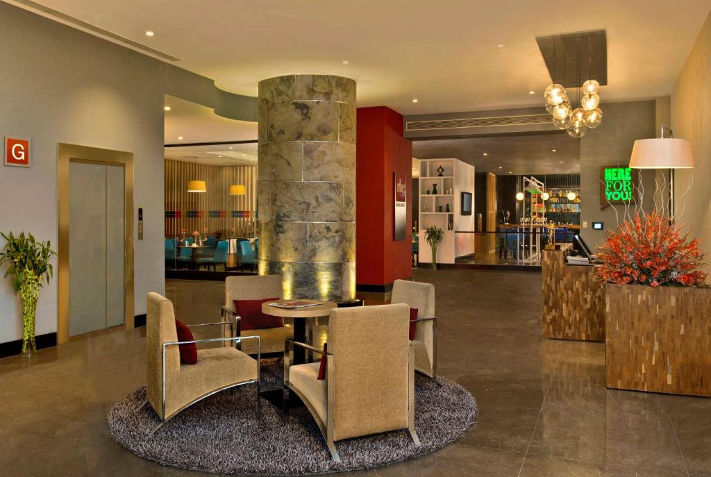 新德里新德里IP扩展区丽柏酒店的大堂设有桌椅和柱子