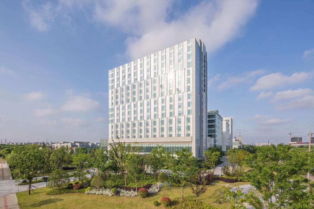 上海上海宝龙丽笙酒店的一座高大的白色建筑,前面有树木