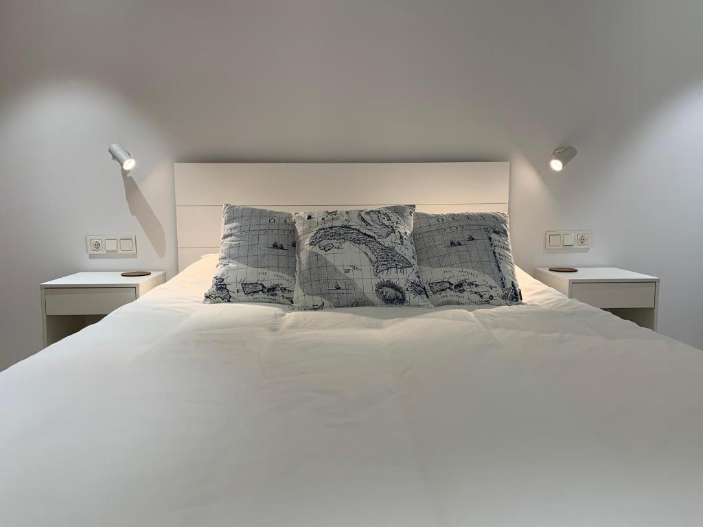 吉塔里亚Aldamar apartamentua PARKING INCLUIDO的一间卧室配有白色床和2个床头柜