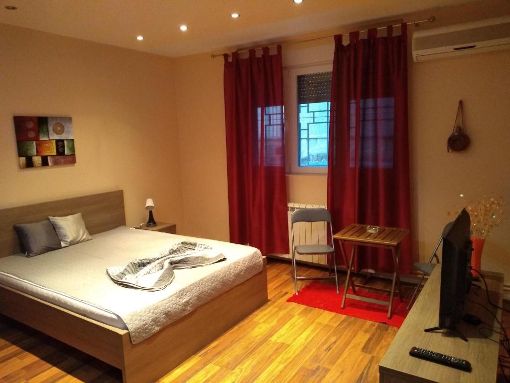 贝尔格莱德Castel Bianco的一间卧室配有一张床、一张书桌和红色窗帘