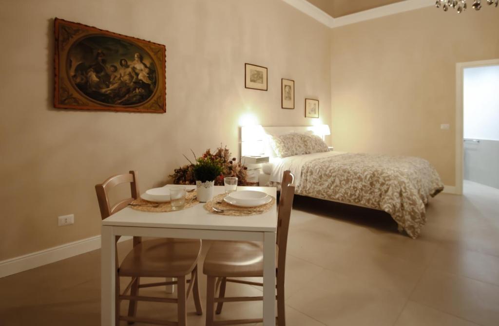 卡塔尼亚Dimora Porta Garibaldi的一间卧室配有一张床和一张桌子及椅子