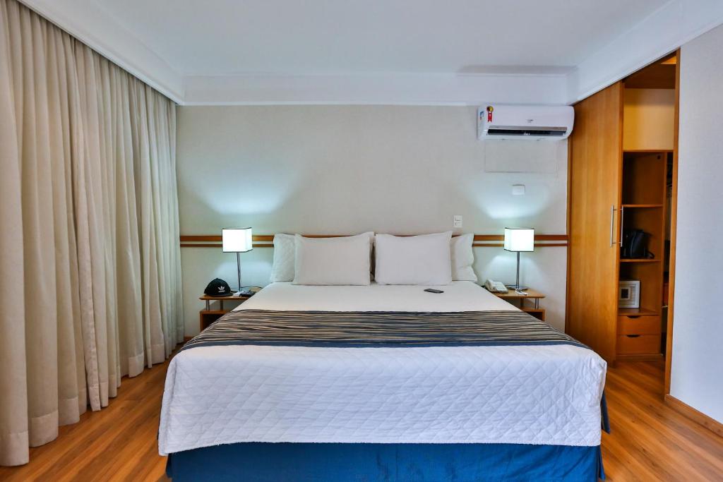 索罗卡巴eSuites Sorocaba by Atlantica的一间卧室配有一张大床和两盏灯。