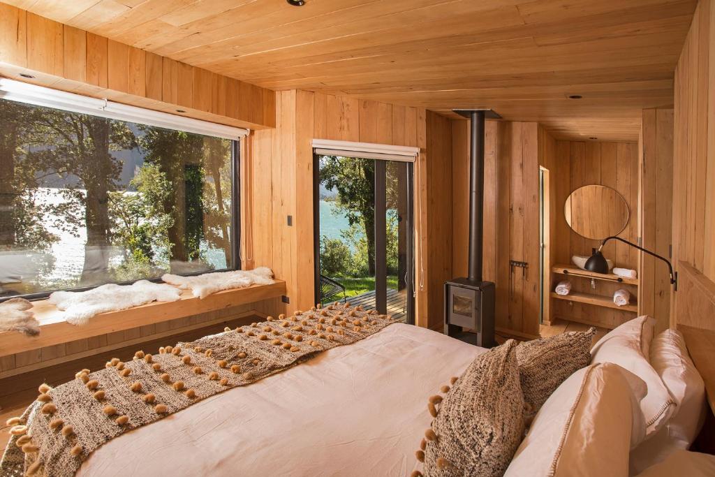 PueloLodge Tagua Tagua, Puelo Patagonia的一间卧室设有一张大床和一个窗户。