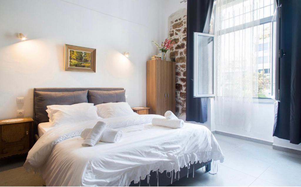 雅典A litte Taste of Home Guest House的一间卧室配有一张带白色床单的床和一扇窗户。
