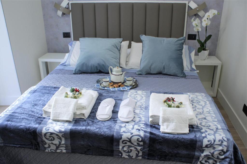 那不勒斯Napoli Mariana Luxury的一张带两条毛巾和一盘食物的床