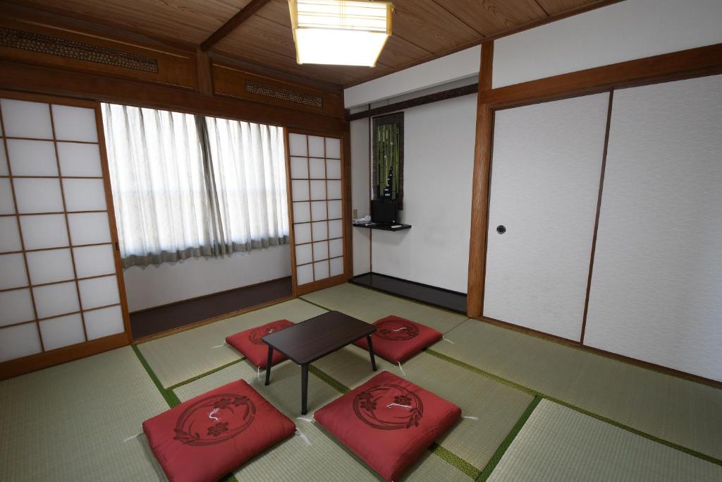 别府Onsenyado Hamayu Nagi的一间空房间,配有红色的椅子和桌子